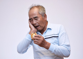お菓子を食べて歯が痛む60代男性
