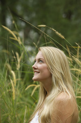 Fototapeta premium Blonde woman in field, smiling