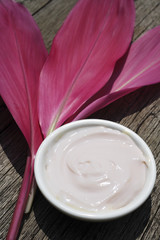 Fototapeta na wymiar Natural yogurt facial and red tropical leaves