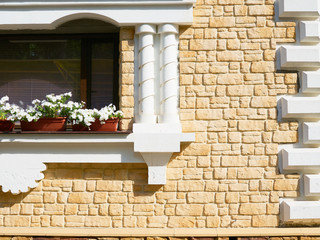 White flowers hangs on the window of a home in an ancient buildi