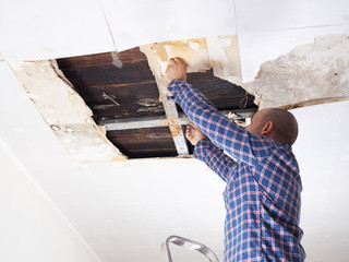 Man repairing collapsed ceiling. - 126490502