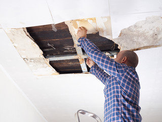 Man repairing collapsed ceiling.