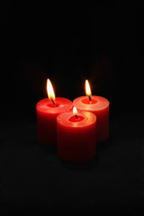 Three lit red candles