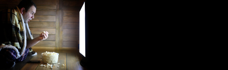 Naklejka premium man watching television at home on the floor