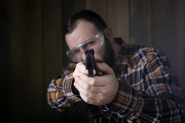 man with put on protective goggles and ear training in pistol sh