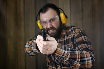 man with put on protective goggles and ear training in pistol sh