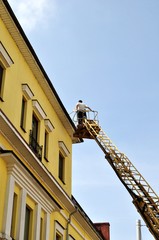 Fototapeta na wymiar Рабочие ремонтируют крышу здания