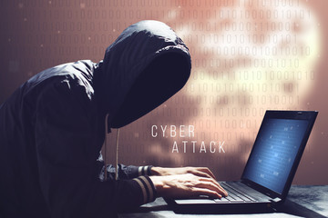 Hacker with laptop initiating cyber attack