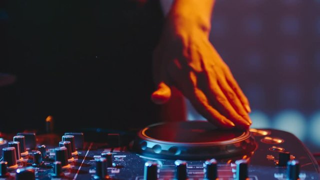Close up of female hands turning knobs on professional DJ mixer console 