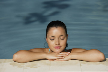 young woman leaning on edge of pool