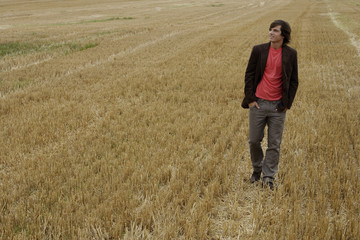Naklejka na ściany i meble Young man standing in a field