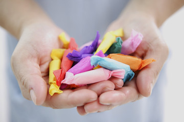 Girl's hands holding paper-wrapped candies