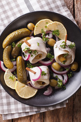 rollmops herring with olives, onions and pickles close up. Vertical top view