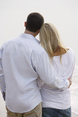 back view of couple standing arm in arm