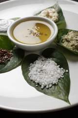 Spa still life of sea salt, scrubs, oils on leaves.