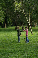 Naklejka na ściany i meble boy and girl holding stick in field