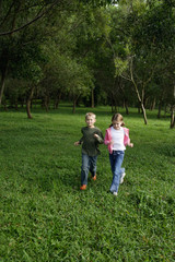 Naklejka na ściany i meble boy and girl running in field