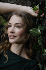 Naklejka premium portrait of woman leaning against tree