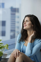 woman enjoying coffee, sitting near window