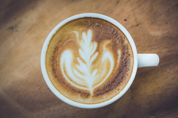 cup of latte coffee on wood table,dark tone