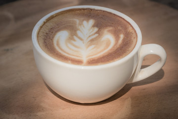 cup of latte coffee on wood table,soft tone