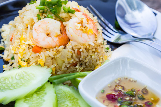 fried rice with shrimp, cucumber and fish sauce on the side