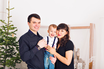 Happy Family and Christmas Tree. Father, Mother And Son. Cute Child. Kid