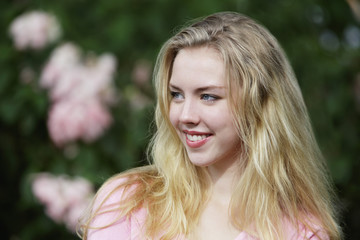 Fototapeta premium Young woman with blonde hair looking away and smiling.