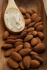 Almonds and almond scrub in wooden spoon.