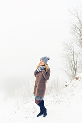 Attractive young woman in wintertime outdoor. Snow and cold