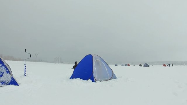 Winter fishing in Siberia - fisher's tents on ice of Ob reservoir in Novosibirsk, Siberia, Russia.