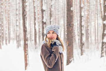 Attractive young woman in wintertime outdoor. Snow and cold