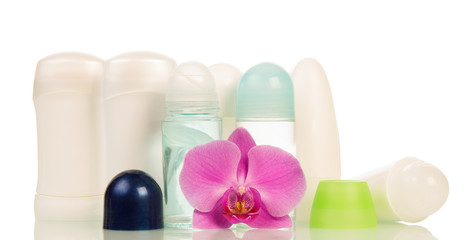 Various deodorant dry and ball, orchid flower isolated on white.