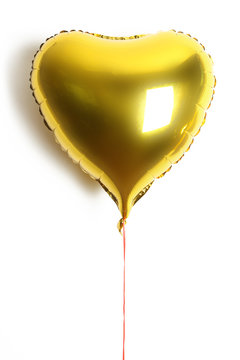 
Gold balloon in the shape of a heart on a white background