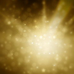 Beautiful gold colored blurry bokeh with blurred star shapes and snowflakes. Magical Christmas and New Year snowy Holiday greeting card copy space background.