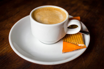 Coffee mug with biscuit on rustic table, vintage style