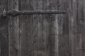 part of shed door consisting of old wooden planks with faded bla