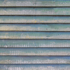 part of shed wall consisting of old wooden planks with faded gre