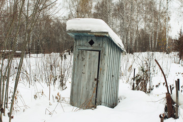 The old toilet is the area of a country house in the winter. Outdoors
