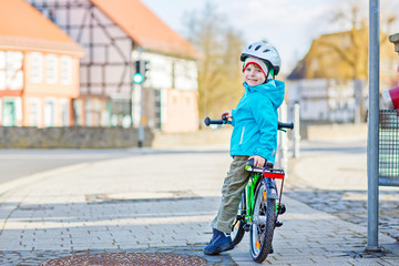 Little preschool kid boy riding on bicycle
