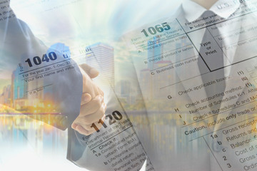 Double exposure of business handshake and tax form for taxation concept