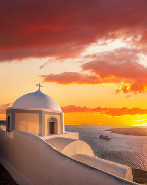 Fototapeta Old Town of Thira on the island Santorini, white church against colorful sunset in Greece