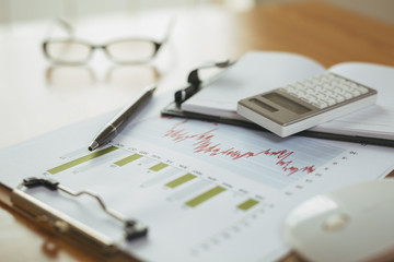 preparation of office desk with office supplies, analysis chart and glasses