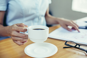 businesswoman pick up coffee cup from her desk