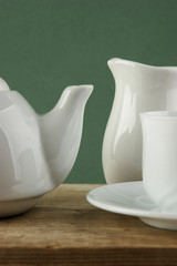 white ceramic coffee set on old wooden table over green backgrou