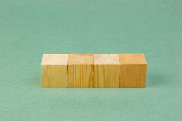 wooden geometric cube on a green background
