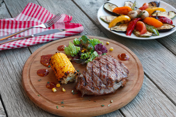 Grilled beef steak closeup on dark wooden table background