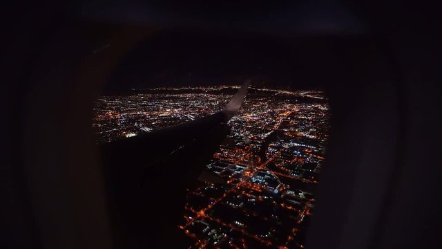 Aerial view from airplane window over Los Angeles City Lights on approach to landing at airport