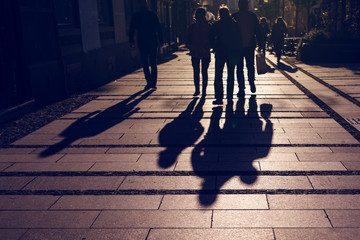 Silhouettes of people walking on city street