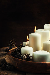 Christmas or New Year's card with burning candles and pine cones
